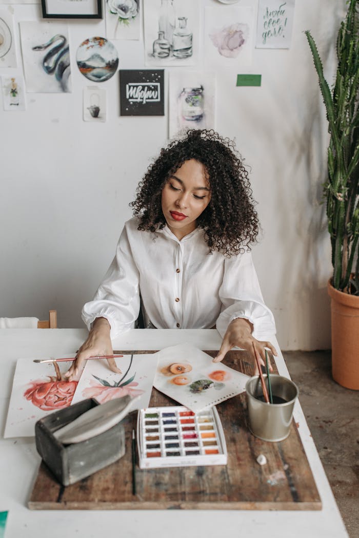 The Art of Drawing Readers In: Your attractive post title goes here A woman painting with watercolors in an artistic workshop surrounded by her creative artworks.