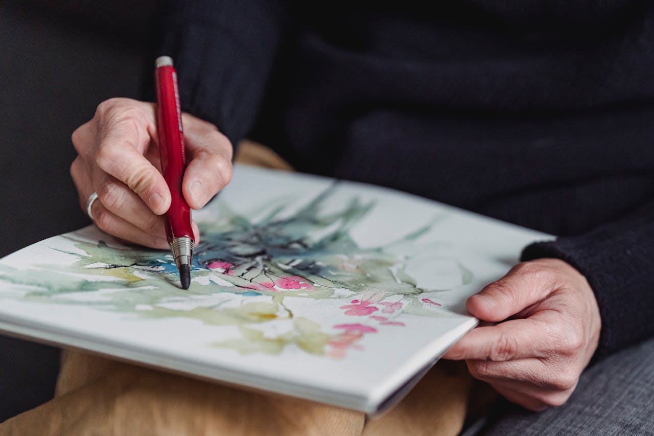 Crafting Captivating Headlines: Your awesome post title goes here Hands sketching a floral watercolor illustration in a creative close-up scene.